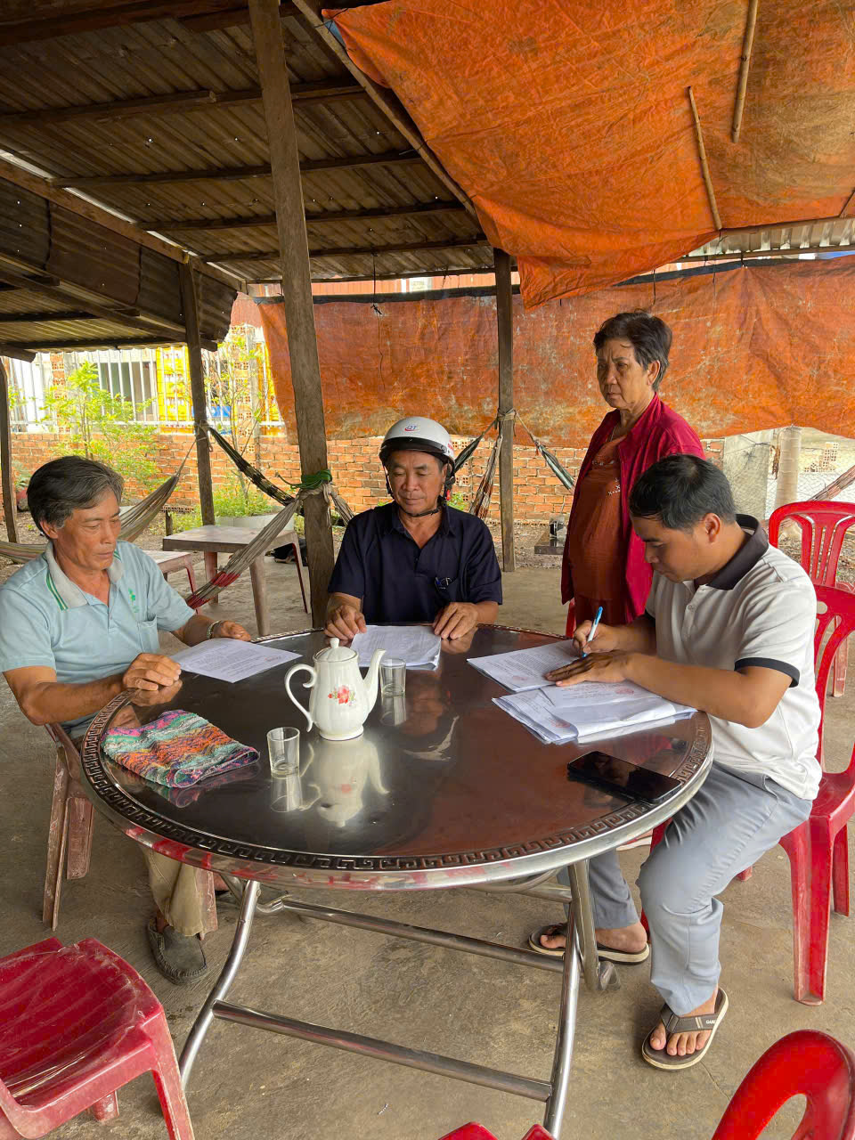 Cán bộ thôn, ấp hướng dẫn người dẫn lấy ý kiến về việc sáp nhập tỉnh, và xã.